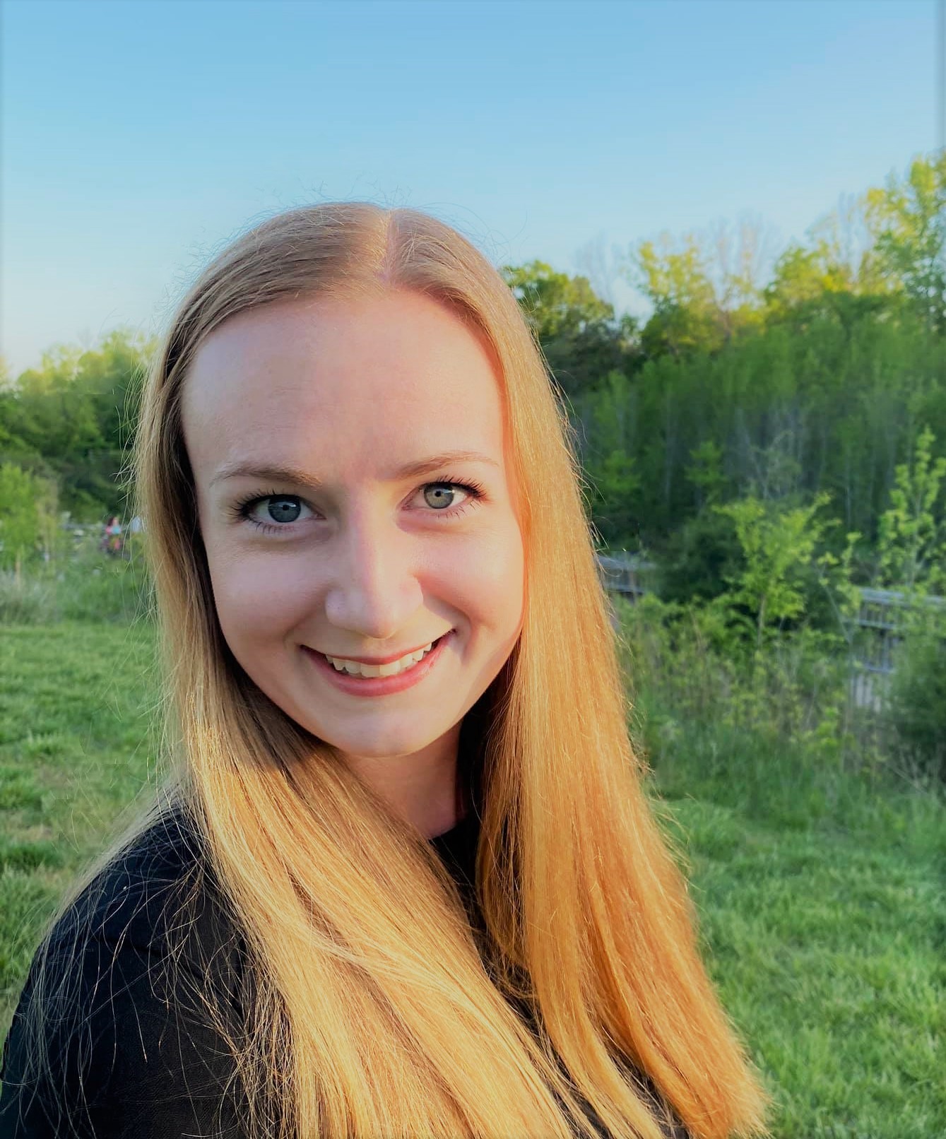 Anna Larson, a CPA in Concord, NC, smiling outdoors in a black top with strawberry-blonde hair.